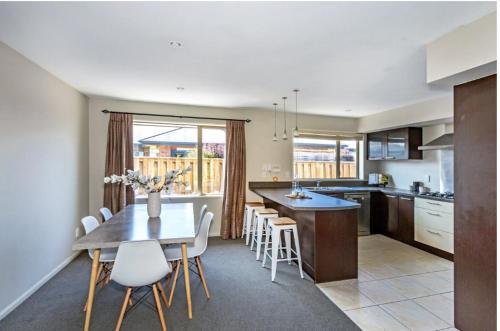 a kitchen with a table and chairs and a dining room at Airport, motorway, shopping handy in Christchurch