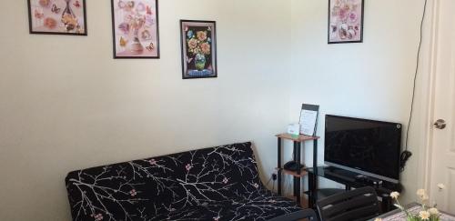 a living room with a couch and a flat screen tv at Two-Bedroom at San Remo Oasis in Cebu City