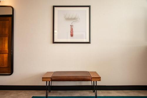 a bench sitting in front of a wall with a picture at Hotel Indigo - Madison Downtown by IHG in Madison