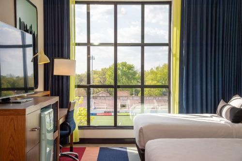 a hotel room with two beds and a large window at Hotel Indigo - Madison Downtown by IHG in Madison