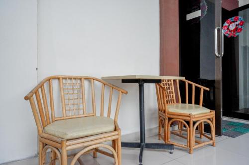 duas cadeiras sentadas ao lado de uma mesa e uma mesa com em RedDoorz @ Hotel Bumi Palupy em Palu