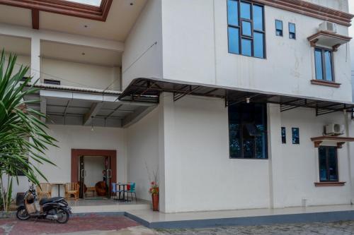 a motorcycle parked in front of a house at RedDoorz @ Hotel Bumi Palupy in Palu