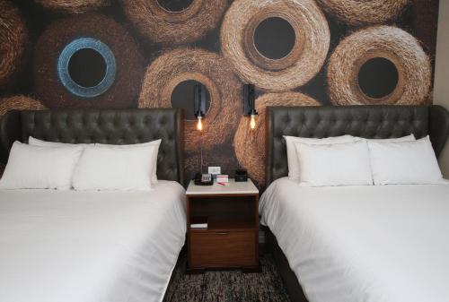 two beds sitting next to each other in a hotel room at Hotel Indigo Naperville Riverwalk by IHG in Naperville