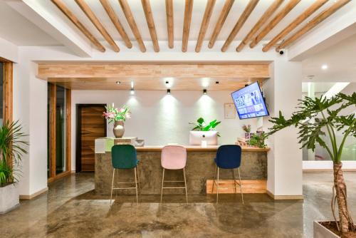 a lobby with a bar with three chairs at Shang Shan ruo shui 大理上山若水客栈 in Dali