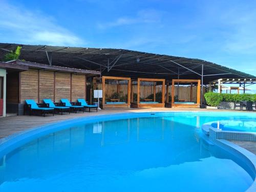 una gran piscina con sillas azules y un edificio en Pacific Crown Hotel, en Honiara