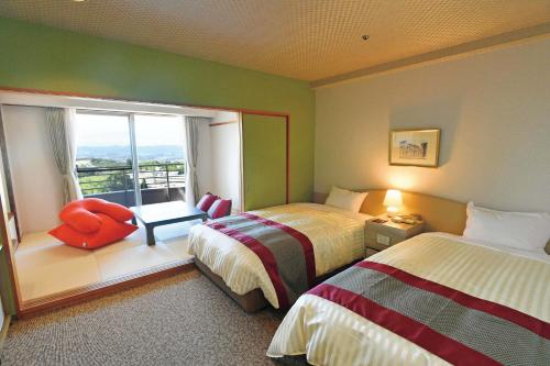 a hotel room with two beds and a window at The Gran Resort Princess Arima in Kobe