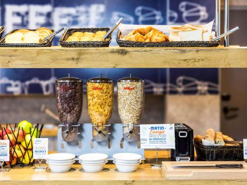 a shelf with three glasses filled with different types of food at ibis budget Givet in Givet