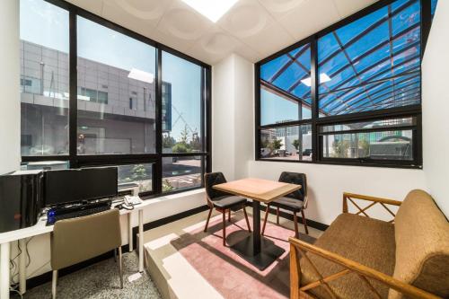 un bureau avec une table, des chaises et des fenêtres dans l'établissement Gimpo Pentastar Hotel, à Gimpo