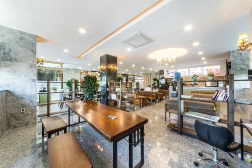 - un restaurant avec des tables et des chaises dans une salle dans l'établissement Gimpo Pentastar Hotel, à Gimpo