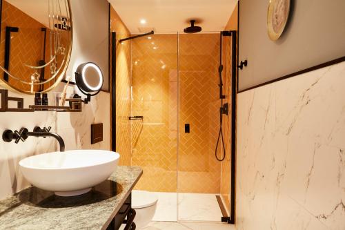 een badkamer met een wastafel en een douche bij Hotel Indigo The Hague - Palace Noordeinde, an IHG Hotel in Den Haag