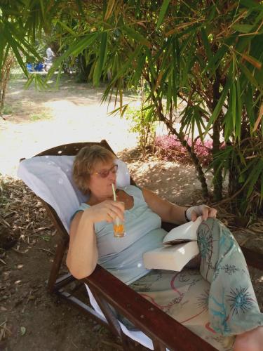 a woman is sitting in a chair with a drink at Marari Bethsaida Homestay in Shertallai