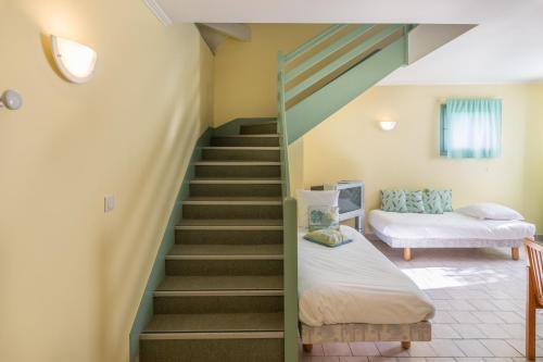 a room with a staircase and two beds in it at Logis Hotel Le Nuage in La Bussière