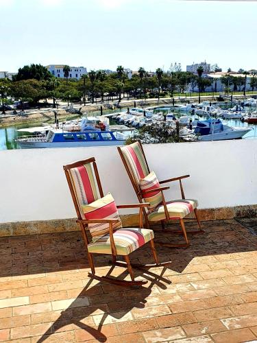 two chairs on a patio with a view of a harbor at El Balcón del Puerto in Ayamonte