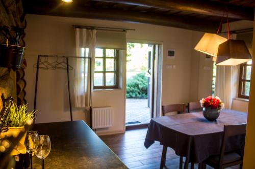 a dining room with a table with chairs and a window at Naktsmājas APĒ in Ape