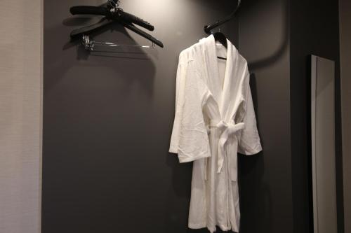 a white robe is hanging on a rack at The Mains Hotel in Cheonan