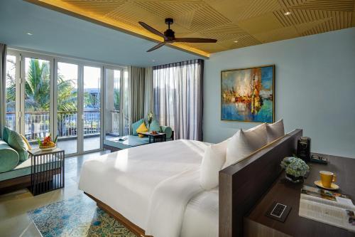 a bedroom with a large bed and a living room at Pullman Phu Quoc Beach Resort in Phu Quoc