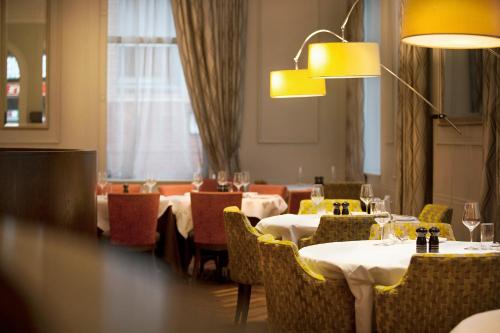 un comedor con mesas, sillas y luces en Hotel Indigo Glasgow, an IHG Hotel, en Glasgow