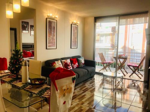 a living room with a couch and a christmas tree at Cosmopolita Rojo in La Serena