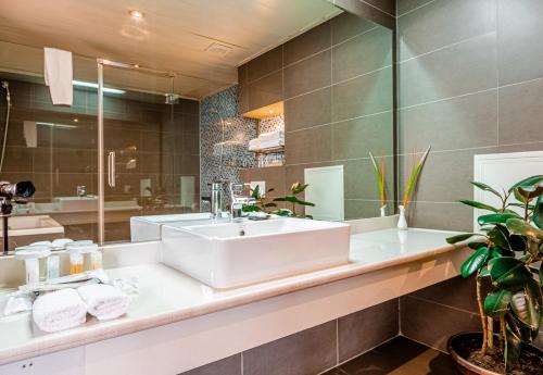 a bathroom with a sink and a large mirror at Ramada Ulaanbaatar City Center in Ulaanbaatar