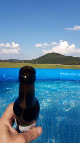 a person holding a beer bottle in a swimming pool at Ferienwohnung FERRUM in Korbach