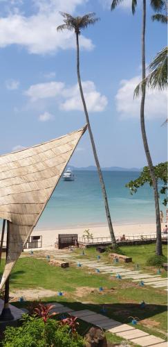 a view of a beach with a palm tree at Anyavee Krabi Beach Resort in Klong Muang Beach