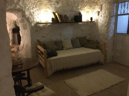 a bedroom with a bed in a stone wall at Casa Cueva “La Estrella” in Granada