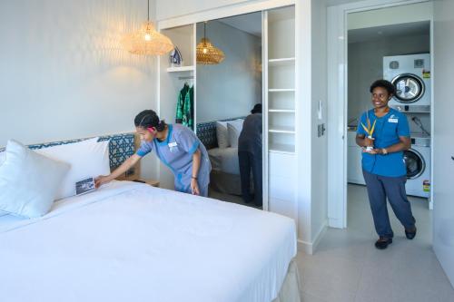 two women standing in a bedroom with a bed at Loloata Island Resort in Loloata Island