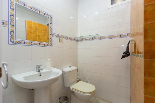 a bathroom with a toilet and a sink and a mirror at BOHEMIA SANLUCAR in Sanlúcar de Barrameda