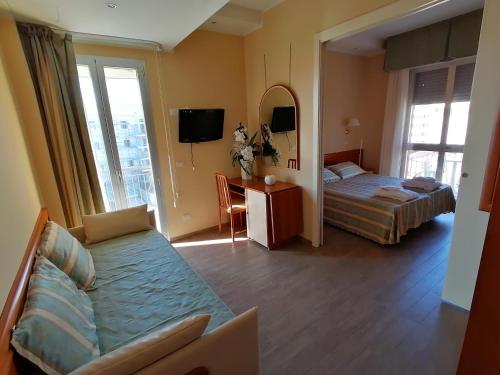 a hotel room with a bed and a couch at Hotel Nordic in Bellaria-Igea Marina