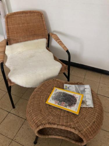 einen Stuhl und einen Tisch mit einer Zeitschrift darauf in der Unterkunft Home Tel Aviv by sourasky medical center ichilov in Tel Aviv