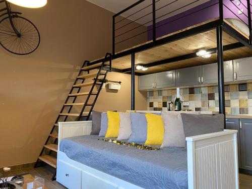 Cama elevada con almohadas amarillas y azules en una habitación en Pedal Apartman Szeged City, en Szeged
