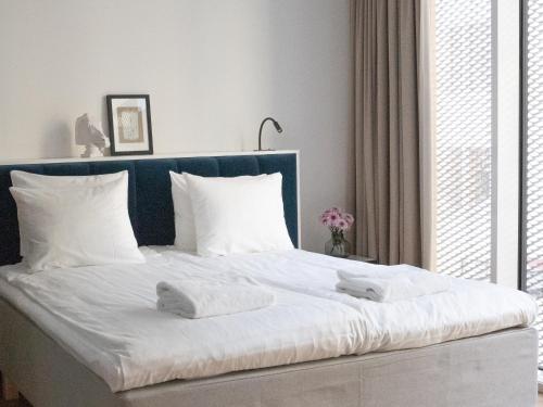 a white bed with two towels on top of it at Bob W Koti Ullanlinna in Helsinki