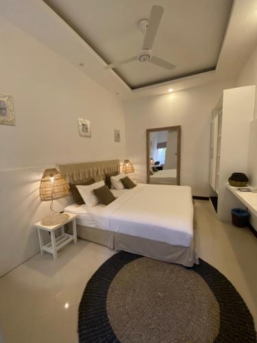 a hotel room with a bed, table and a lamp at Canopus Retreat Thulusdhoo in Thulusdhoo