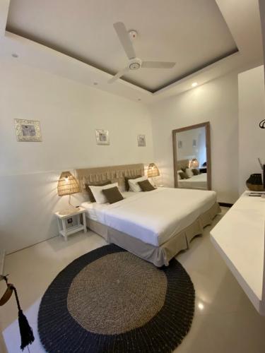 a bedroom with a large bed and a large mirror at Canopus Retreat Thulusdhoo in Thulusdhoo