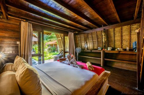 een slaapkamer met een bed in een kamer met houten wanden bij Kelapa Cottage in Amed