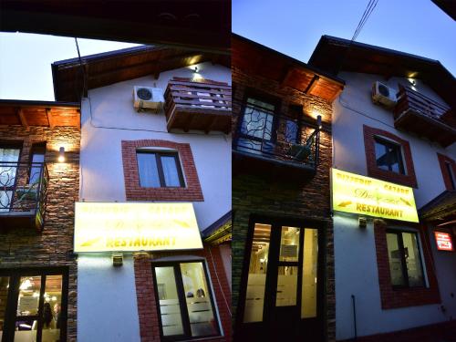 a building with signs on the side of it at Pensiunea Dely_Cios in Vălenii de Munte