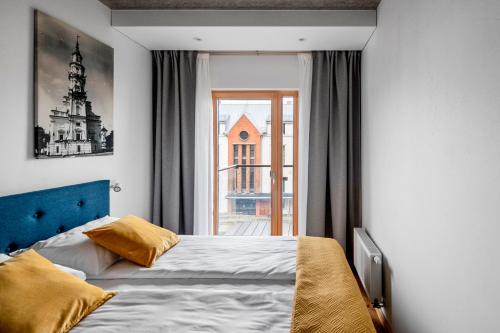 a bedroom with a bed and a large window at King Mindaugas Apartments in Kaunas