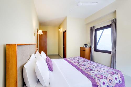 a bedroom with a large white bed with a window at Mount Himalayan Hotel in Gangtok