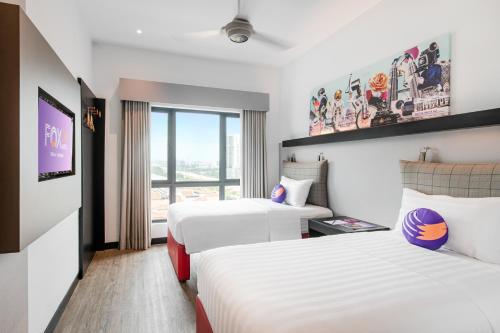 a hotel room with two beds and a window at FOX Lite DPulze Cyberjaya by Ascott in Cyberjaya
