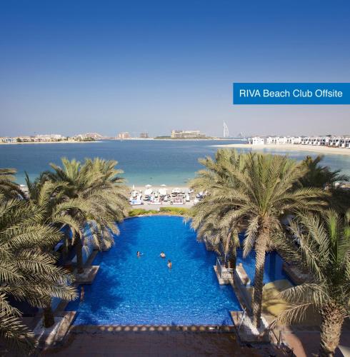 an overhead view of a swimming pool with palm trees at Mövenpick Hotel Jumeirah Lakes Towers Dubai in Dubai