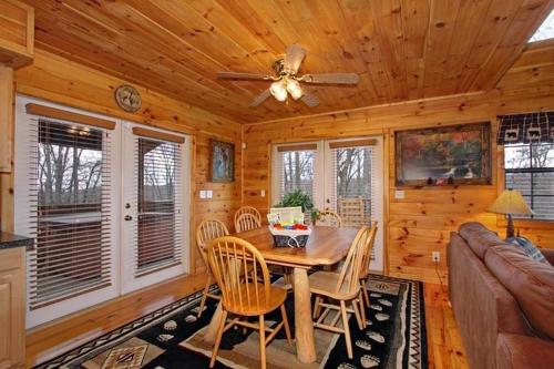 uma sala de jantar com uma mesa e uma ventoinha de tecto em Secluded Memories Cabin em McCookville