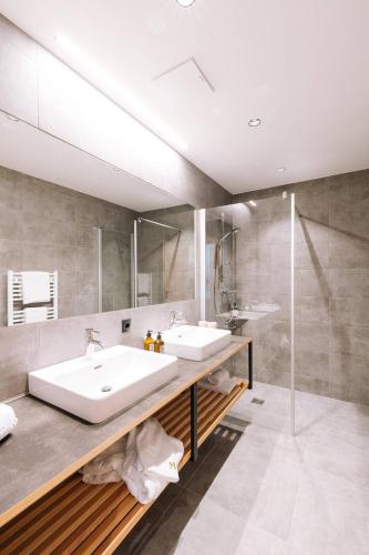 a bathroom with two sinks and a shower at Thalers Mariandl in Schladming