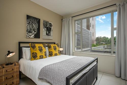 a bedroom with a bed and a large window at The Tyrwhitt Rosebank Apartments in Johannesburg