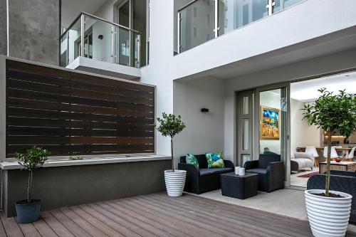 Casa con balcón con sillas y mesas. en The Tyrwhitt Rosebank Apartments, en Johannesburgo