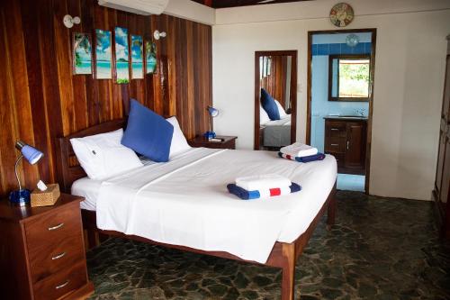 a bedroom with two beds with blue and white pillows at Rainbow Bay Beach & Dive Resort in Siquijor