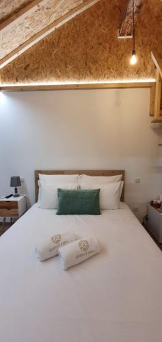 a white bed with two pillows on top of it at Quinta d'Areda Wine&Pool Experience in Fafe
