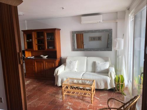 sala de estar con sofá blanco y mesa en Apartamento frente al mar (Avda costa Blanca), en Alicante
