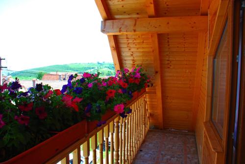 a balcony with flowers on a wooden fence at Pensiunea IULIA in Rod