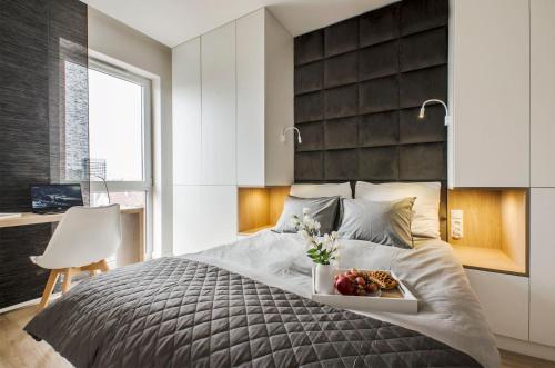 a bedroom with a bed with a tray of food on it at SKY Home- Ilumino Apartment -Centrum, Parking, Klimatyzacja, Dostęp na Kod in Łódź