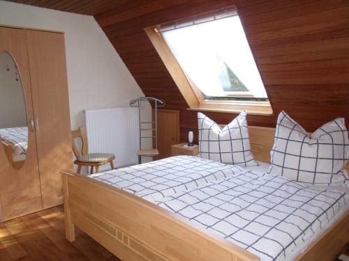 a bedroom with a bed with pillows and a window at Ferienwohnung Lehmann 15090 in Leer